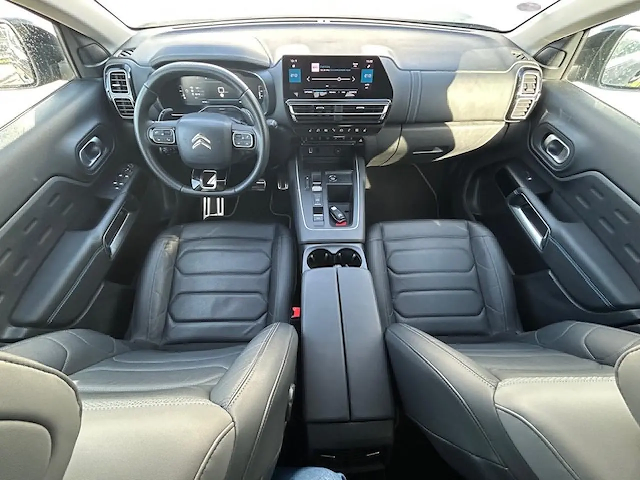 Vue intérieure du poste de conduite du Citroën C5 Aircross 2022, avec sièges cuir noirs et tableau de bord moderne.