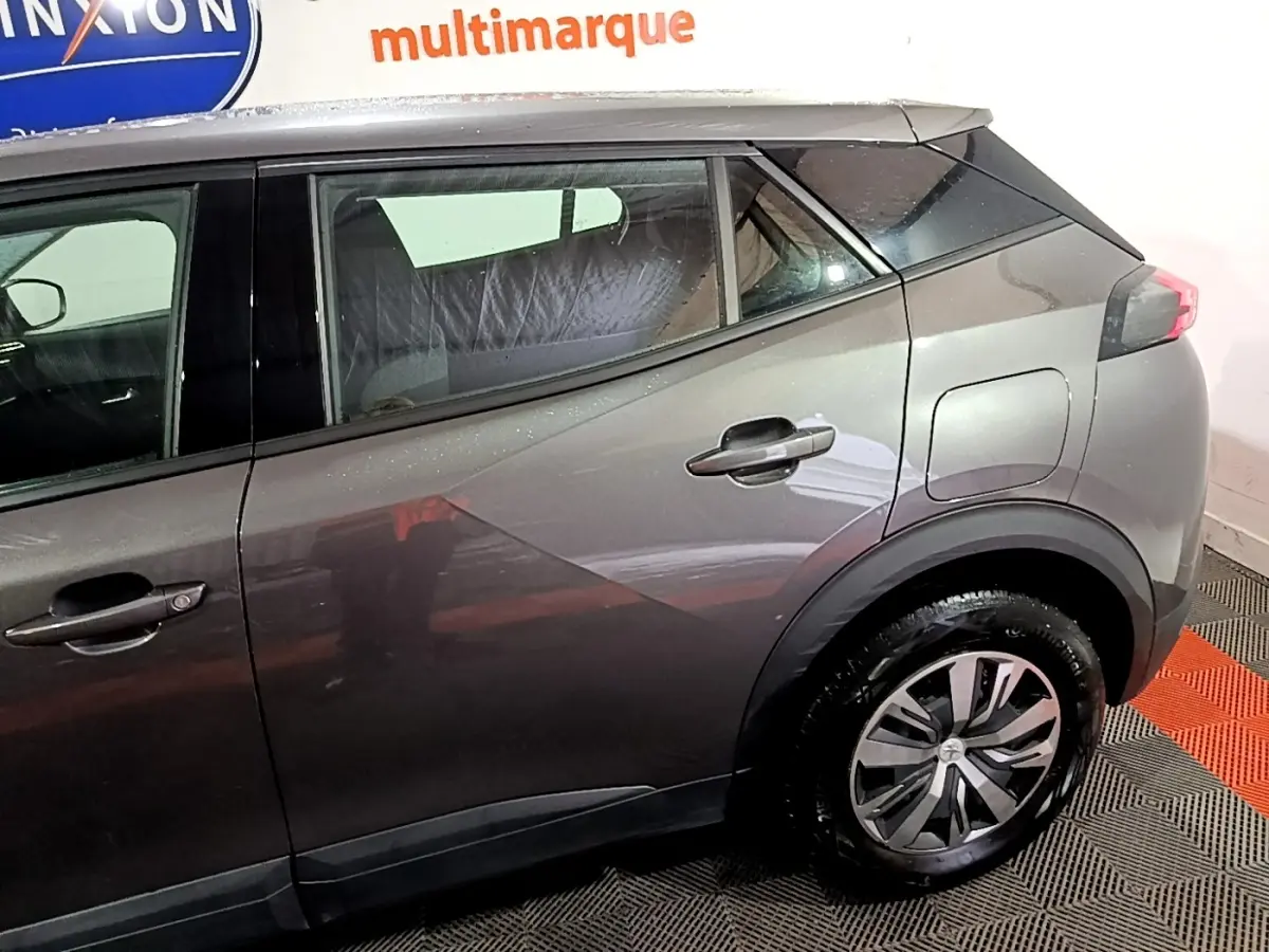 Vue latérale droite d’un Peugeot 2008 gris clair, mettant en valeur la ligne de caisse et les jantes modernes.