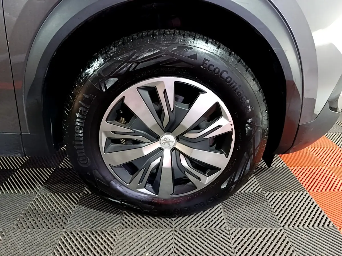 Gros plan sur la roue avant droite d’un Peugeot 2008 gris clair avec jante alliage et pneu Continental EcoContact 6.
