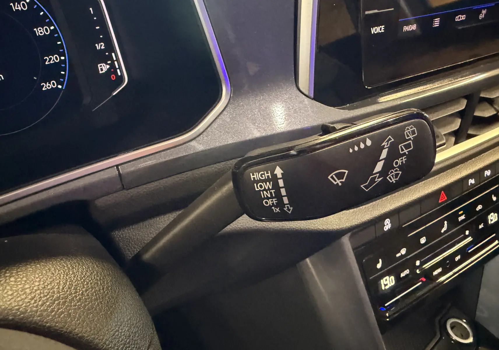 Gros plan sur la manette d’essuie-glace côté gauche du tableau de bord du Volkswagen T-Roc bleu 2022.