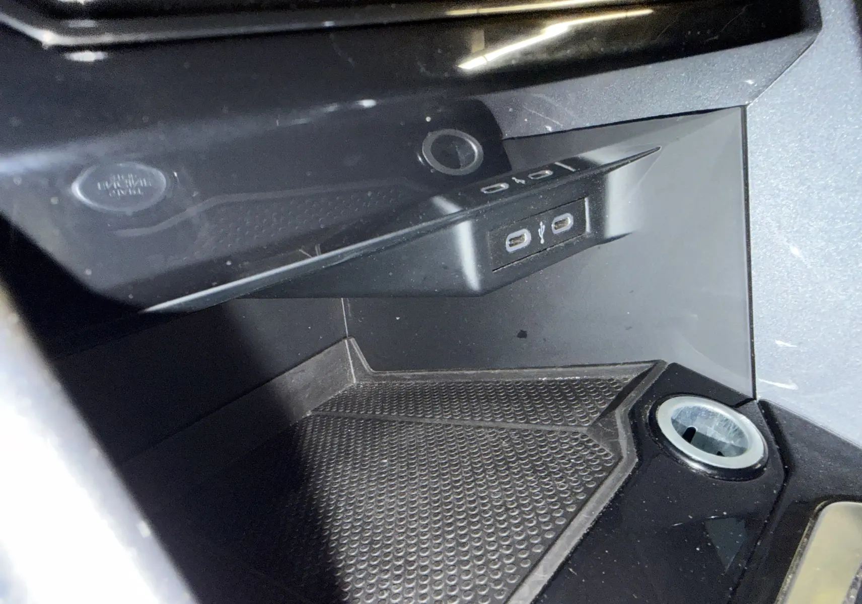 Gros plan sur la console centrale du Volkswagen T-Roc bleu 2022, montrant prises USB et allume-cigare.