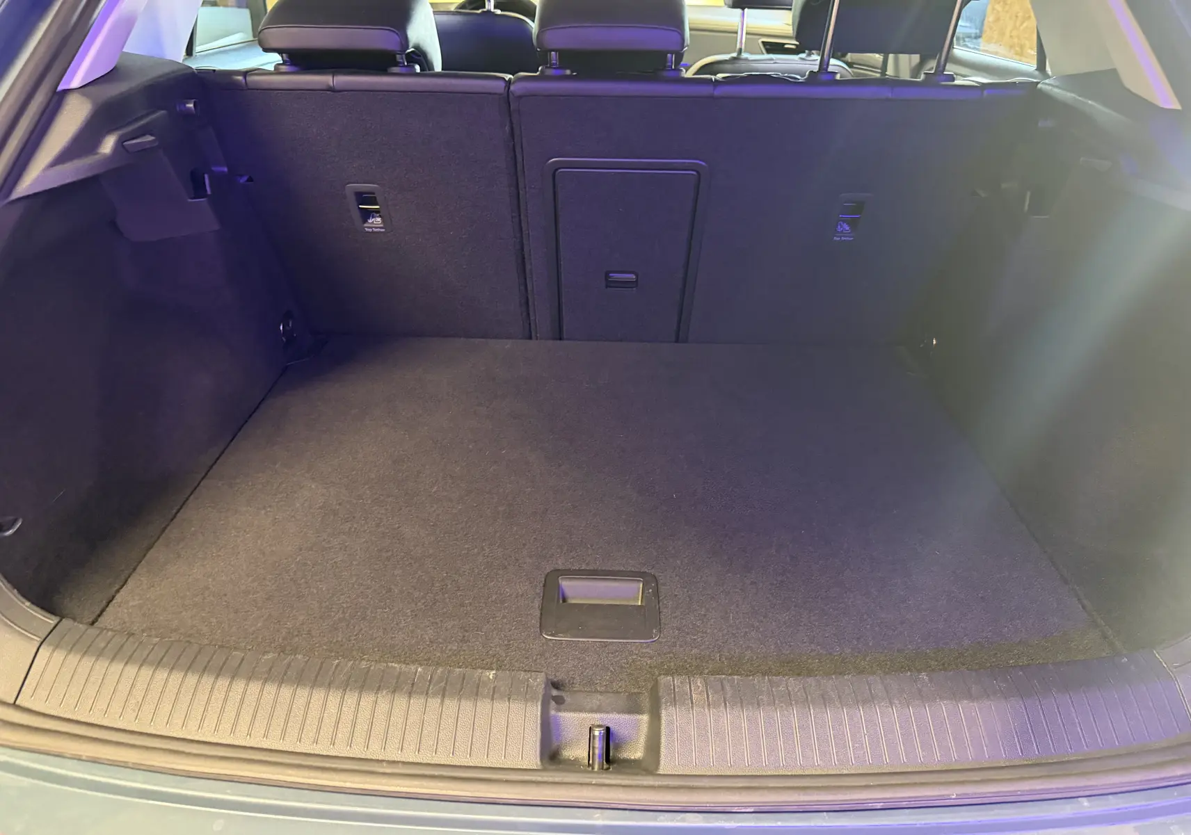 Vue du coffre ouvert du Volkswagen T-Roc bleu 2022, montrant l'espace de chargement et le dossier des sièges arrière.