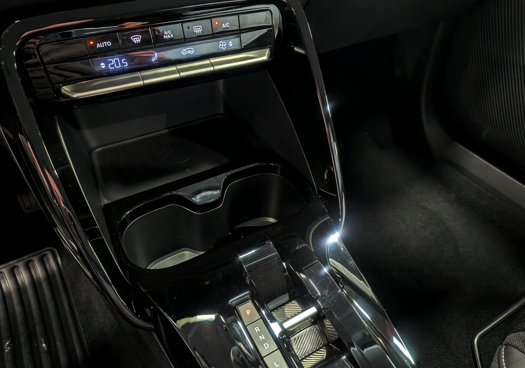 Gros plan sur la console centrale noire brillante de la Citroën C3 Aircross hybride 2026 avec commandes climatisation et levier de boîte auto.