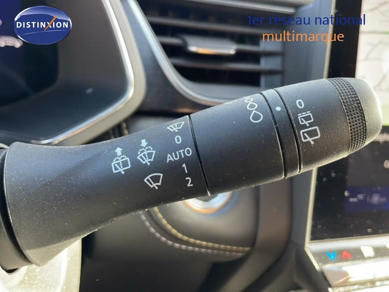 Gros plan sur la commande d’essuie-glace à gauche du volant dans l’habitacle du Renault Symbioz gris cassiopée métal.