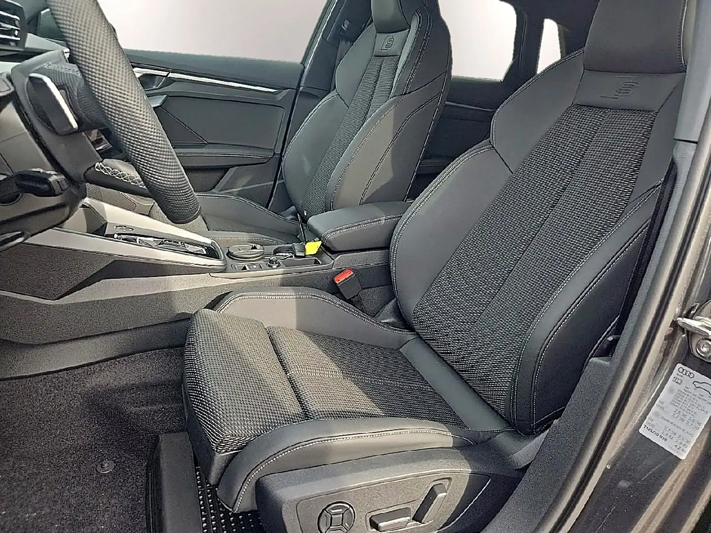 Vue intérieure côté conducteur de l’Audi A3 Sportback 2026 avec sièges sport gris et volant cuir multifonction.