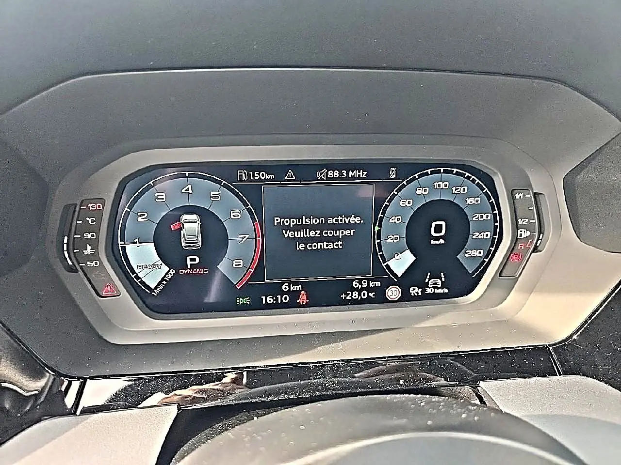 Vue rapprochée du tableau de bord numérique de l'Audi A3 Sportback 2026 affichant la vitesse et un message d'alerte.