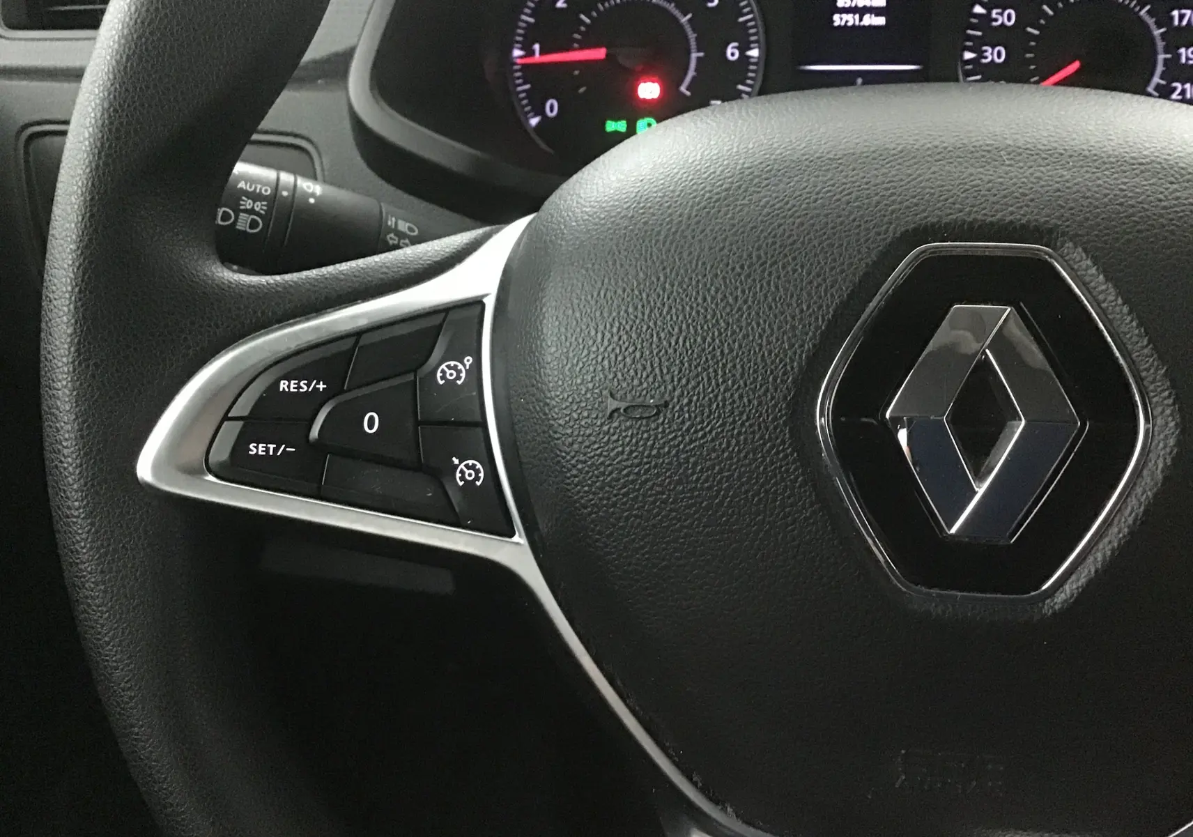 Gros plan sur le volant noir du Renault Express Van 2021, avec commandes de régulateur de vitesse et logo Renault central.