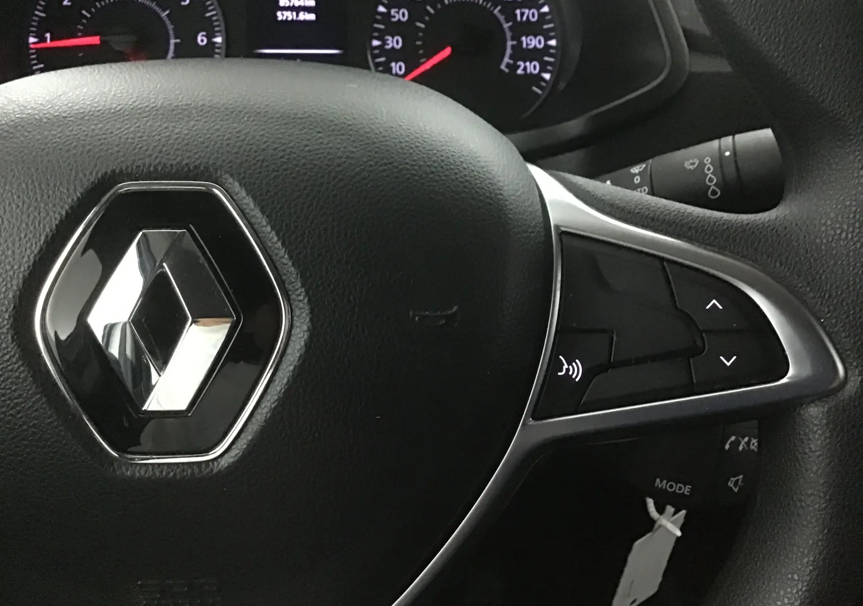 Gros plan sur le volant noir du Renault Express Van 2021 avec commandes intégrées et logo chromé central.