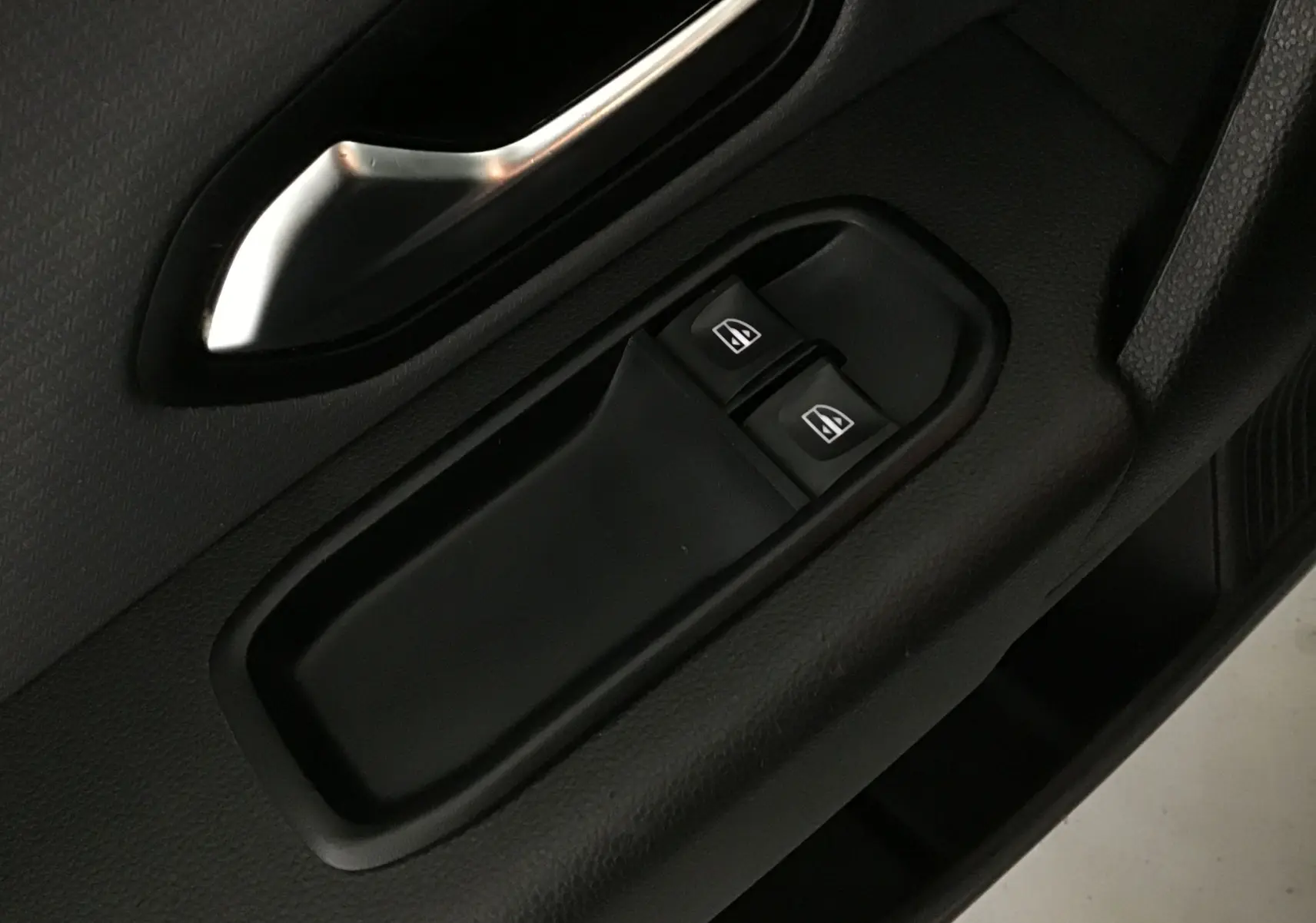 Gros plan sur les commandes de lève-vitres côté conducteur du Renault Express Van blanc, finition Confort GPS 2021.