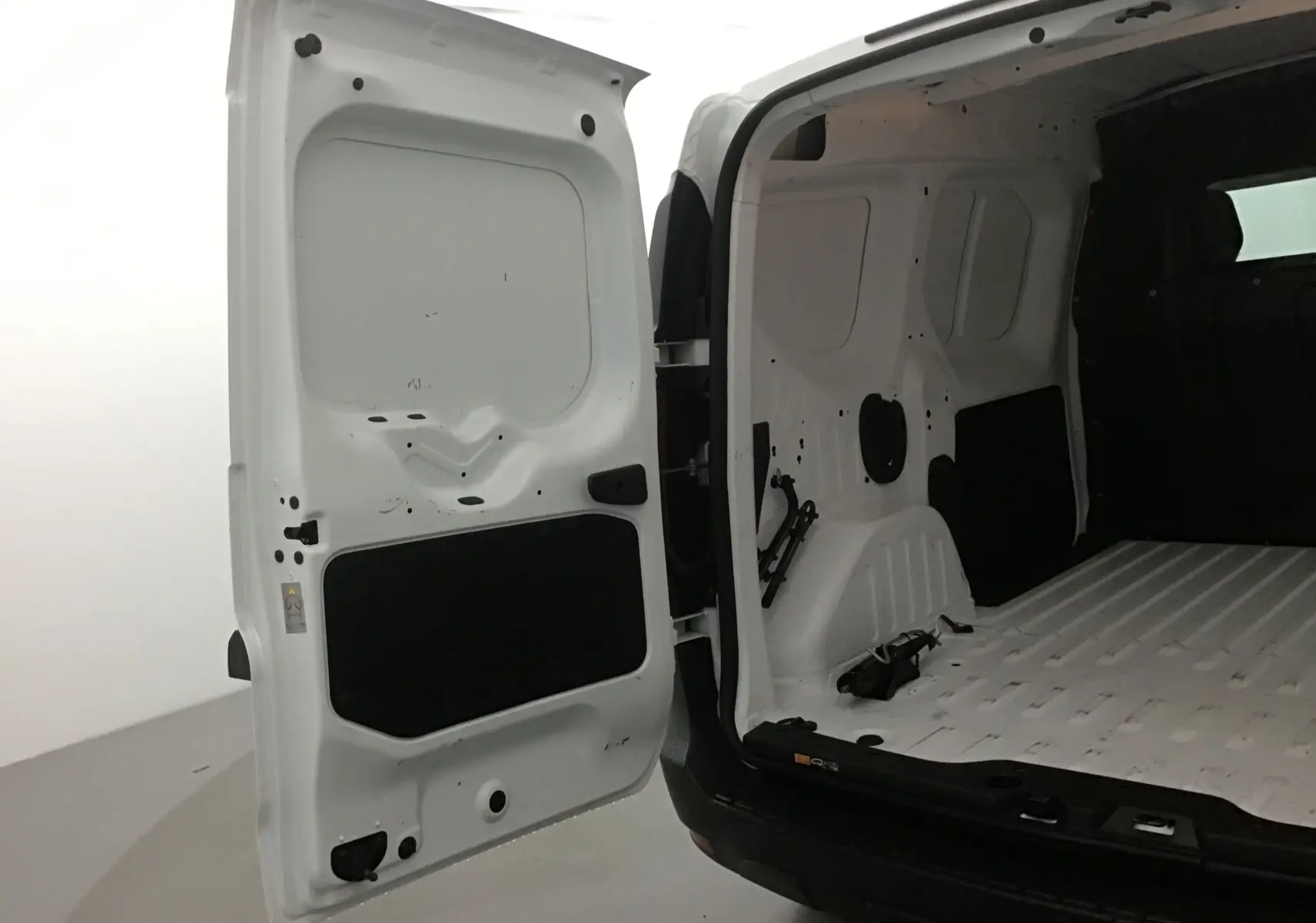 Vue intérieure arrière du Renault Express Van blanc 2021 avec porte ouverte montrant l'espace de chargement vide.