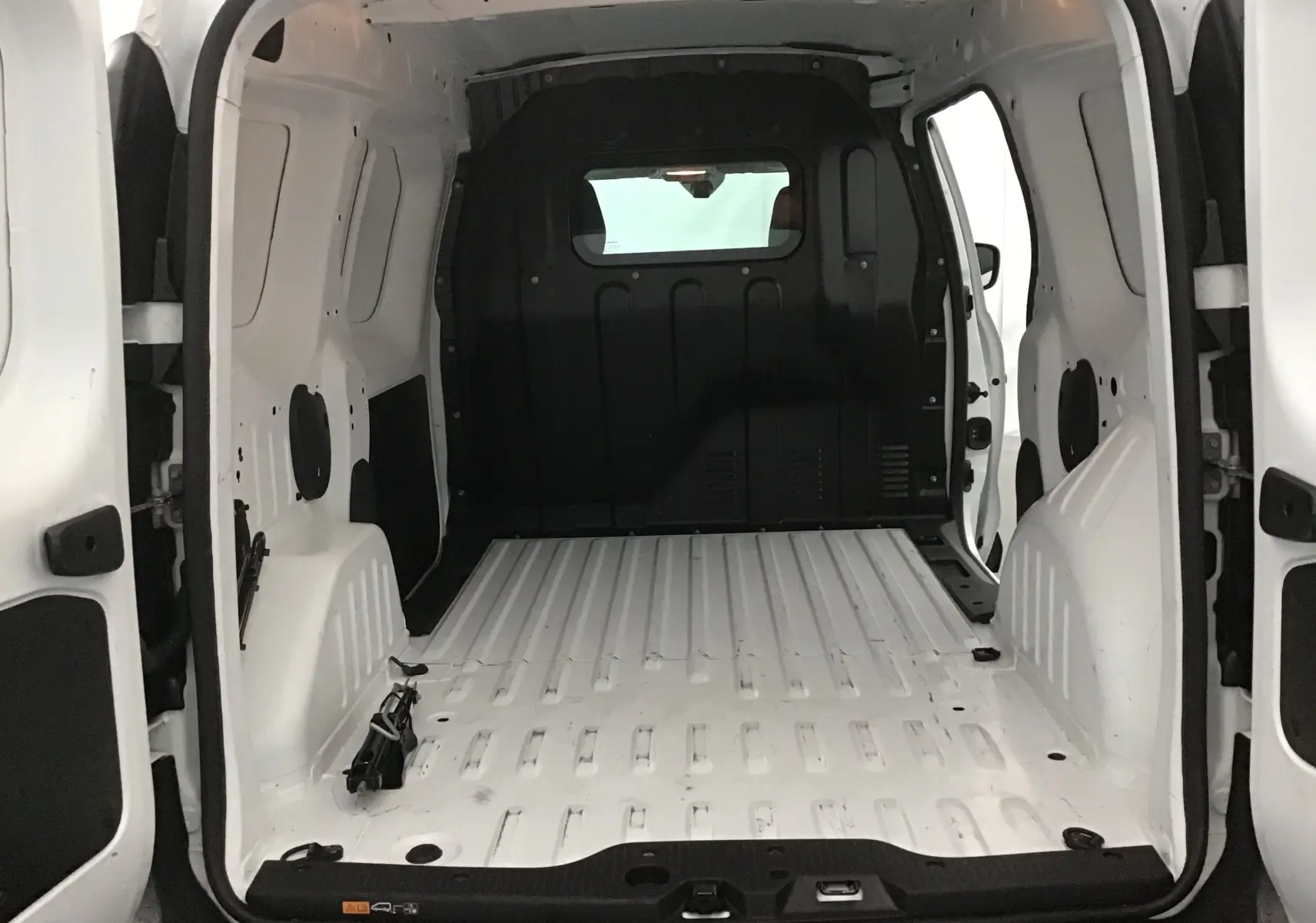 Vue intérieure arrière du Renault Express Van blanc 2021, montrant l'espace de chargement vide et la cloison noire.