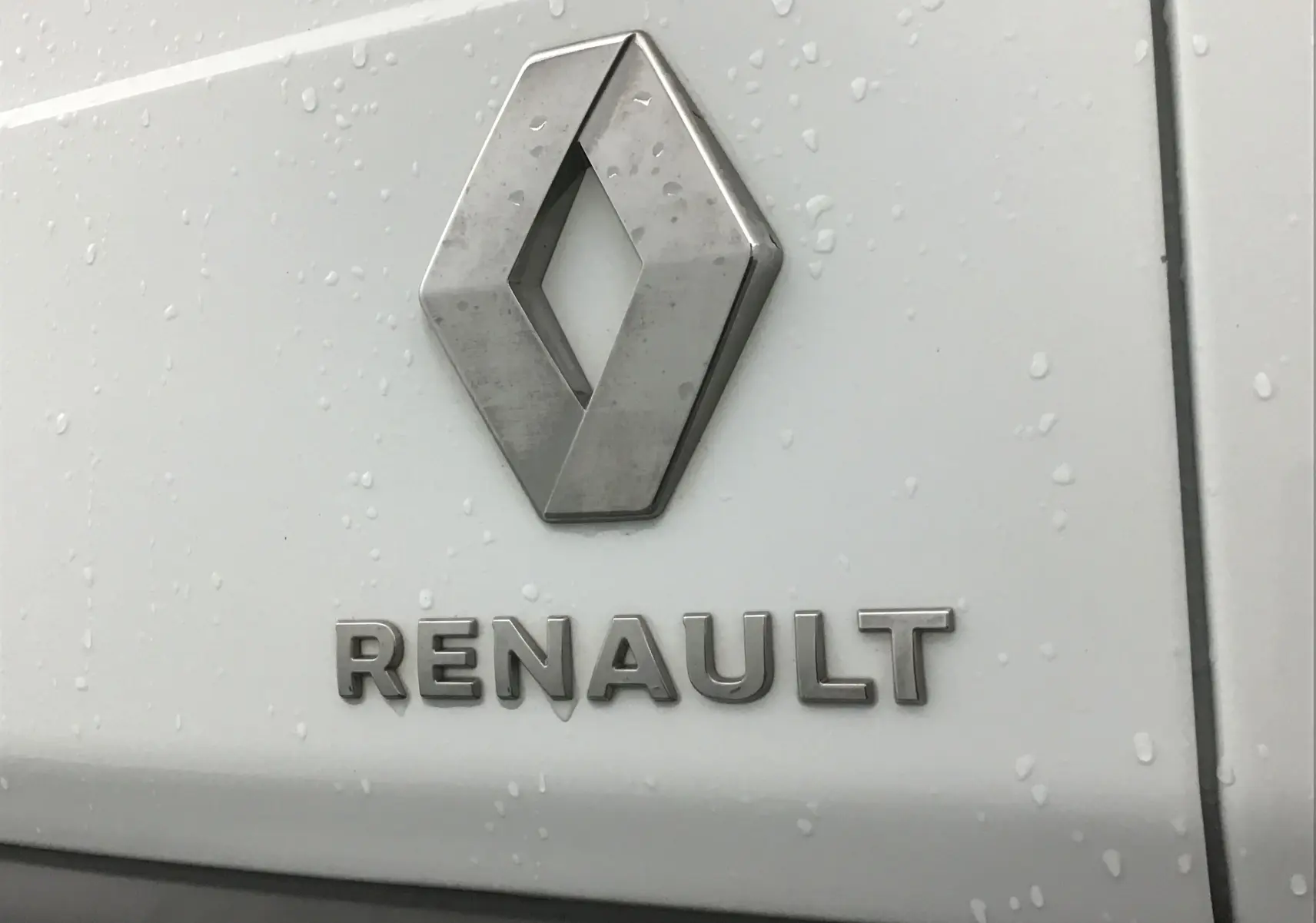 Gros plan sur l'emblème Renault en métal sur la porte arrière blanche d'un utilitaire Express Van 2021.