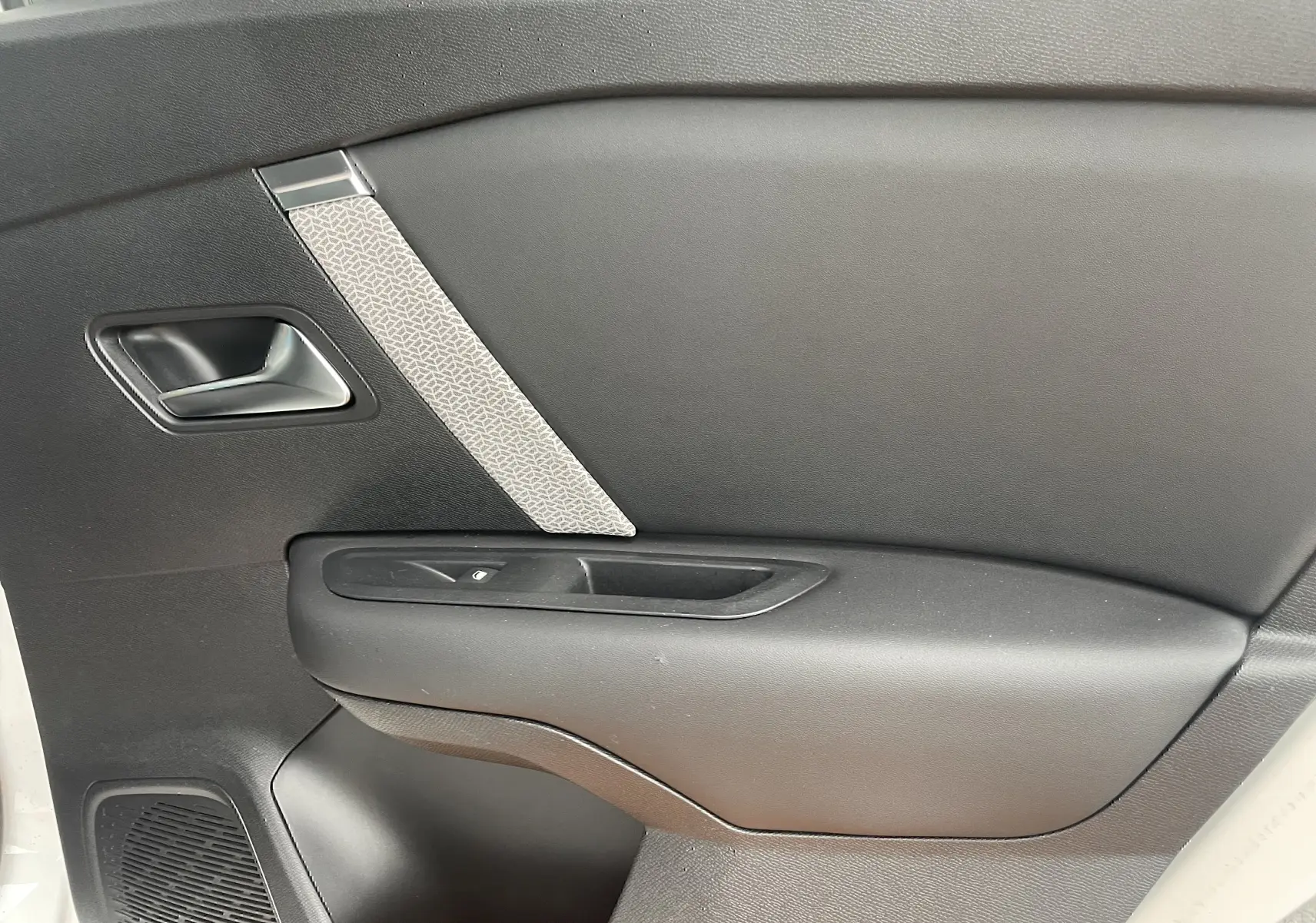 Gros plan sur la porte côté gauche intérieure noire avec insert gris clair d'une Citroën C4 blanche 2022.