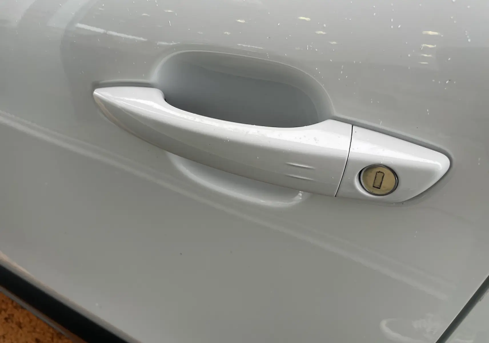 Poignée de porte blanche côté droit de la Citroën C4 1.2 PureTech 130 Shine avec serrure visible sur la portière.