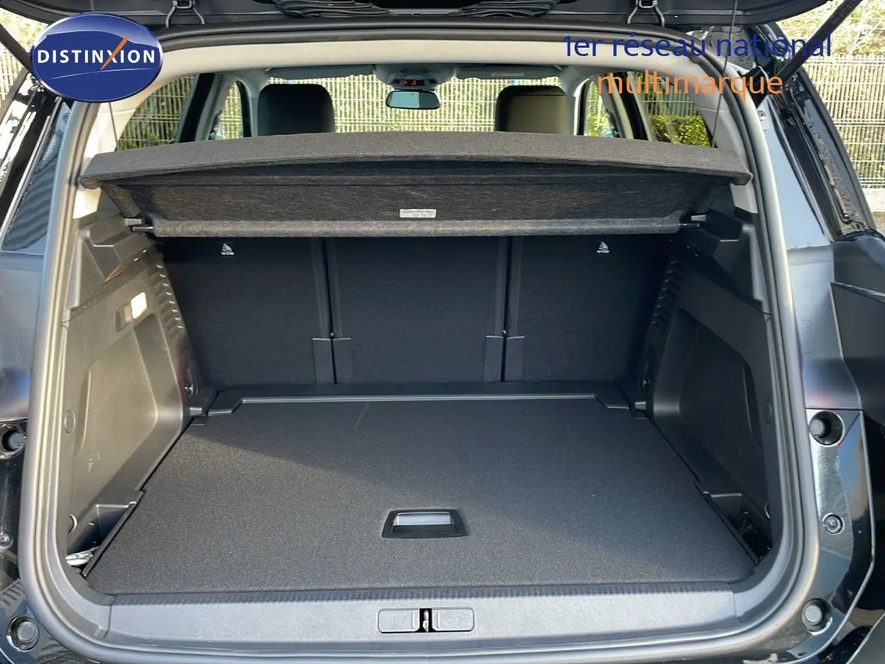 Coffre ouvert vu de l'arrière d'un Citroën C5 Aircross noir Perla Metal avec cache-bagages en place.