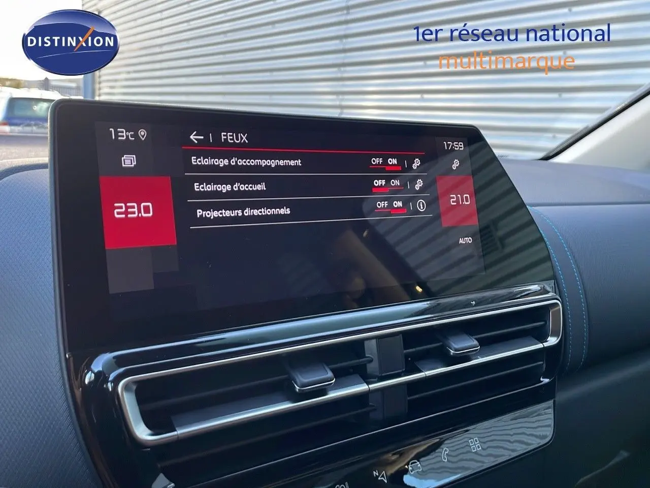 Écran tactile du tableau de bord du Citroën C5 Aircross, affichant les réglages des feux, avec finition cuir noir et surpiqûres bleues.