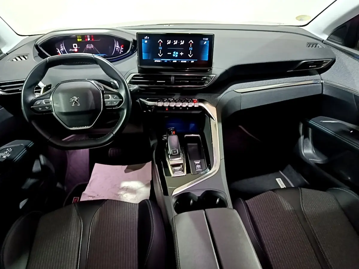 Intérieur Peugeot 3008 noir vue avant du poste de conduite avec volant cuir, écran tactile central et levier de boîte automatique.