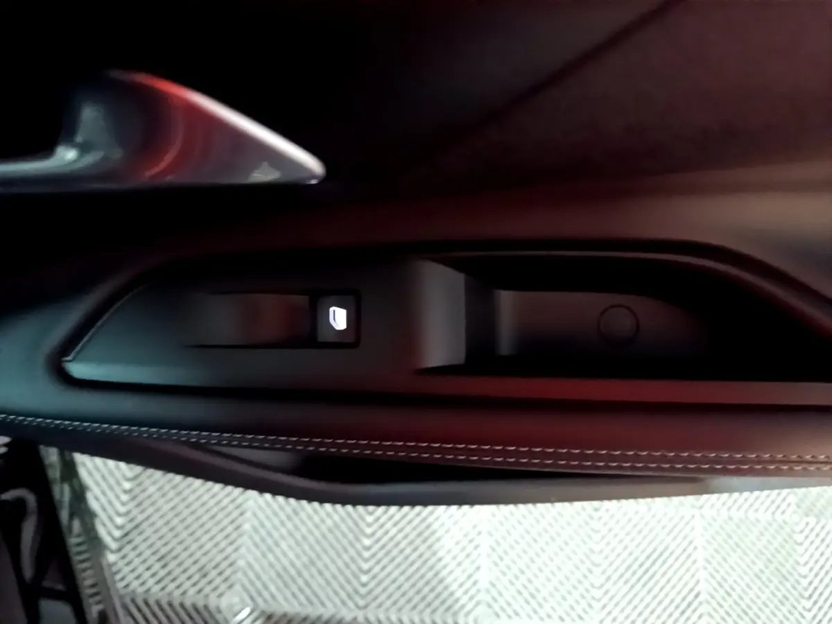 Détail de la poignée intérieure côté gauche du Peugeot 3008 noir avec bouton de verrouillage éclairé.