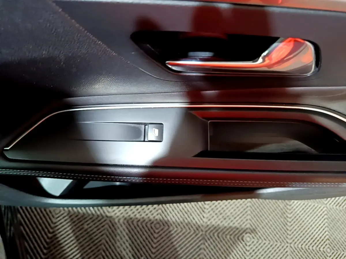 Détail de la poignée de porte intérieure noire avec commande de vitre sur le côté gauche du Peugeot 3008 2022.