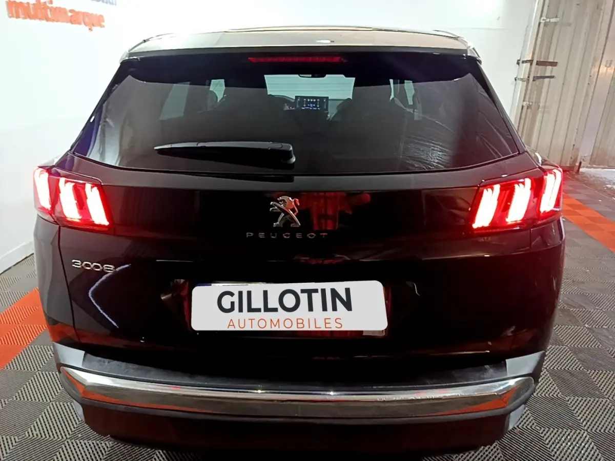 Vue arrière d’un Peugeot 3008 noir avec feux arrière LED allumés dans un garage fermé.