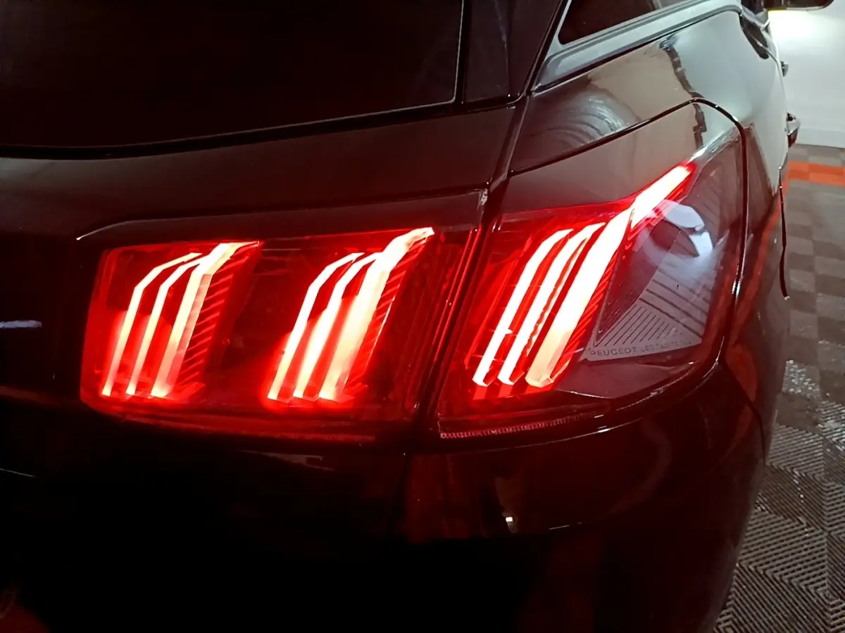Gros plan sur le feu arrière droit allumé d’un Peugeot 3008 noir, soulignant son design LED distinctif.
