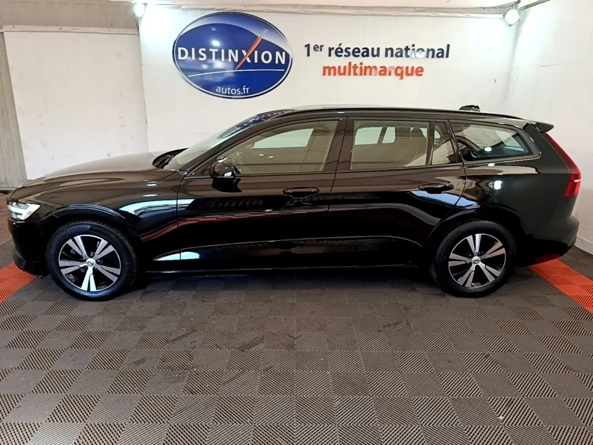Profil côté gauche d’un break Volvo V60 noir 2020, avec jantes alliage et feux arrière LED visibles en intérieur showroom.