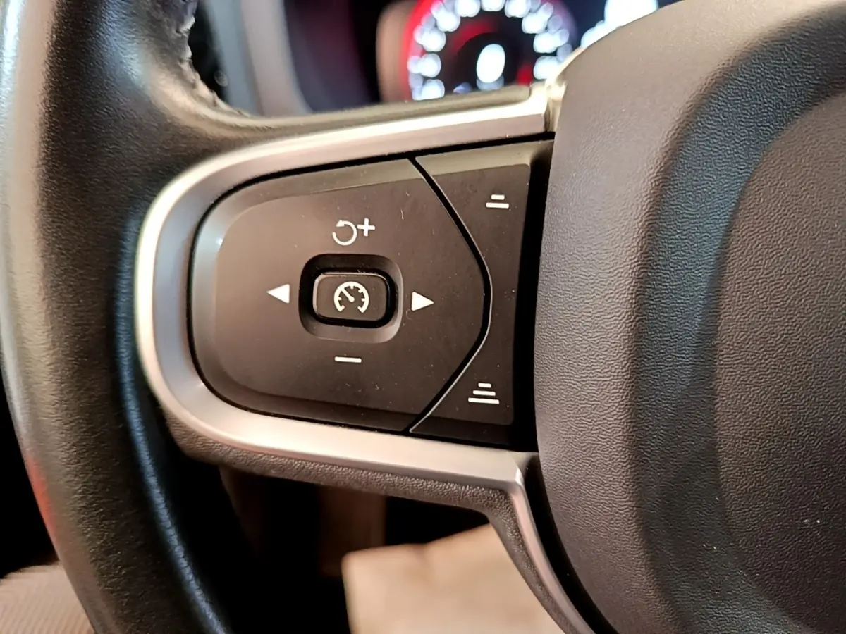 Gros plan sur les commandes de régulateur de vitesse au volant cuir noir du Volvo V60 D3 Business 2020.