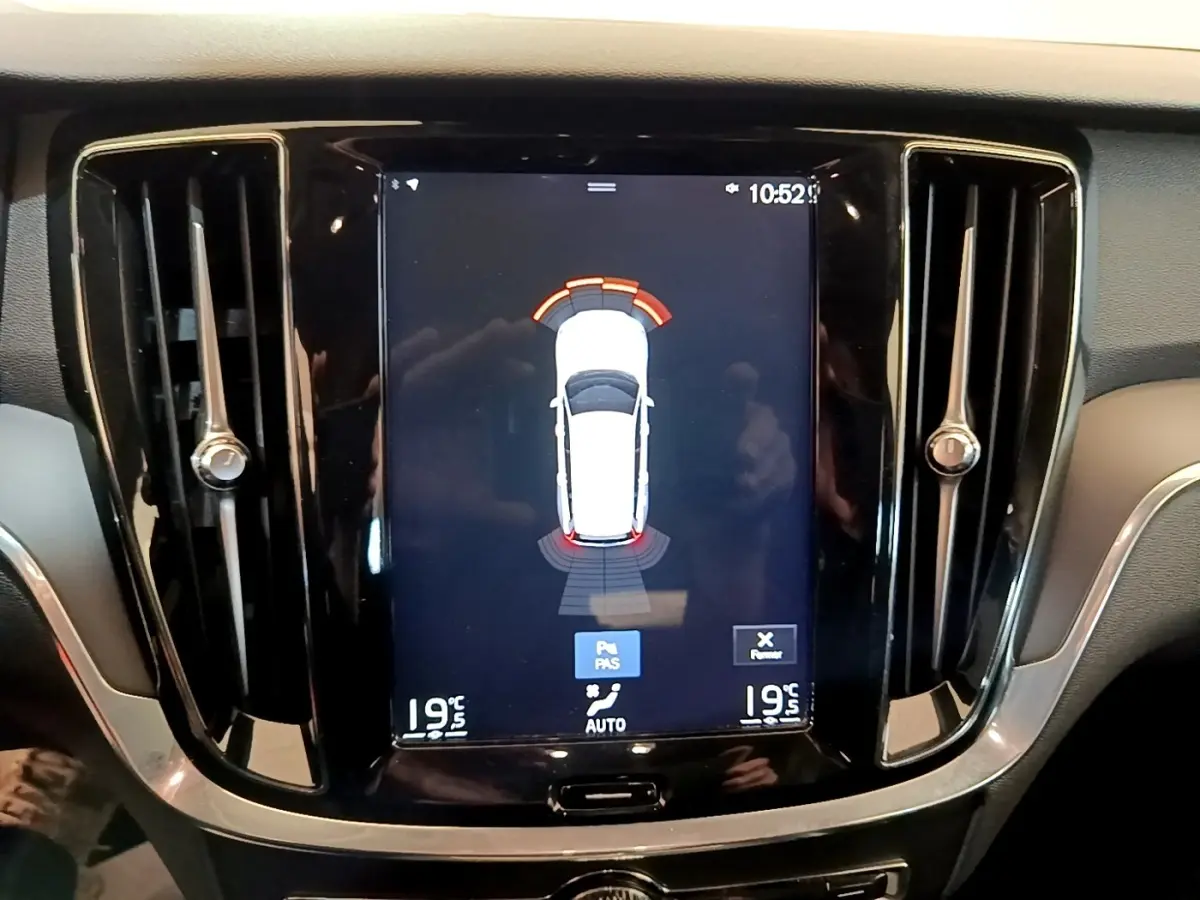 Vue rapprochée de l’écran tactile central noir du tableau de bord du Volvo V60 D3 Business 2020 affichant l’aide au stationnement.