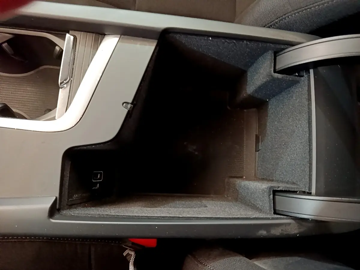 Vue plongeante sur le rangement central noir intérieur de la Volvo V60 D3 AdBlue 2020 avec prise USB visible
