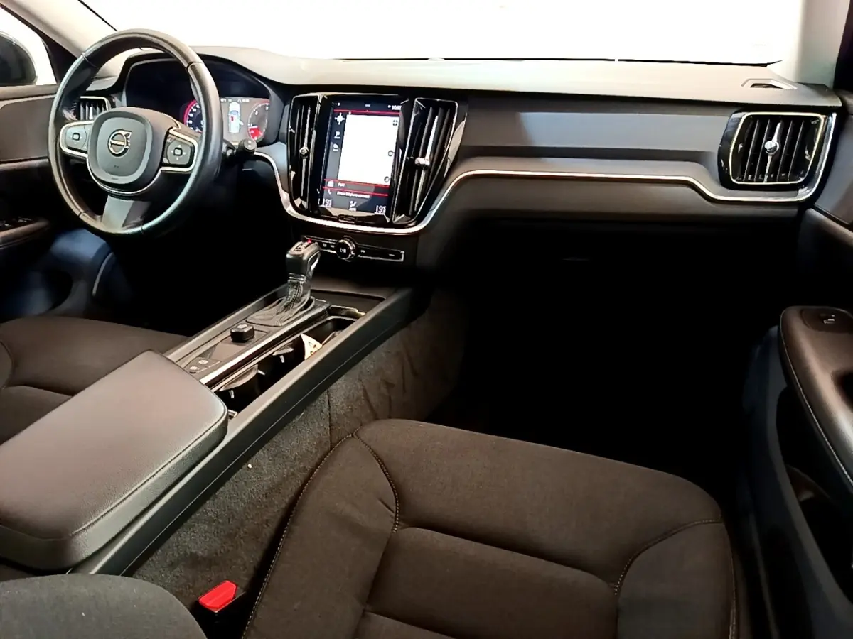 Intérieur noir de la Volvo V60 2020 vu côté conducteur, avec tableau de bord moderne et écran tactile central vertical.