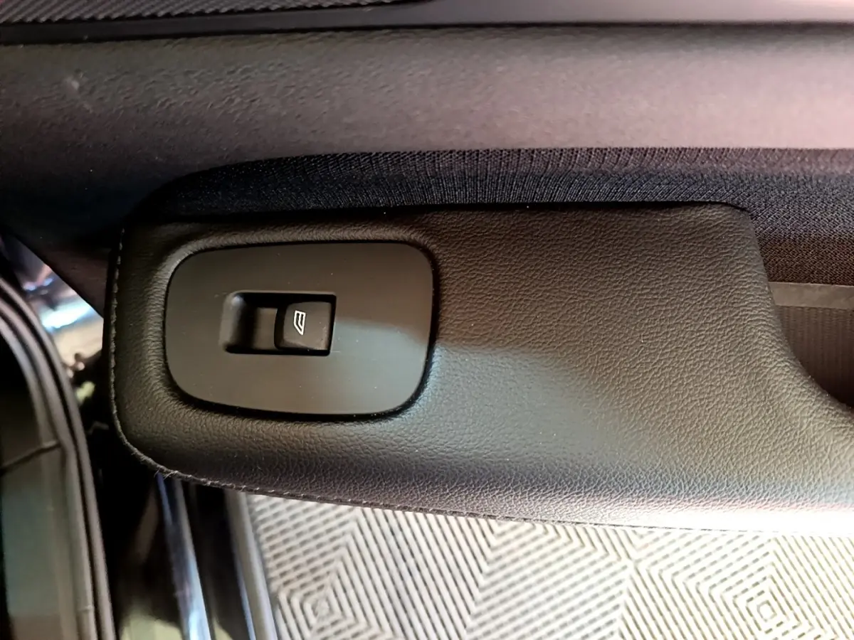 Bouton de commande de lève-vitre sur la portière intérieure noire d'une Volvo V60 D3 Business 2020.