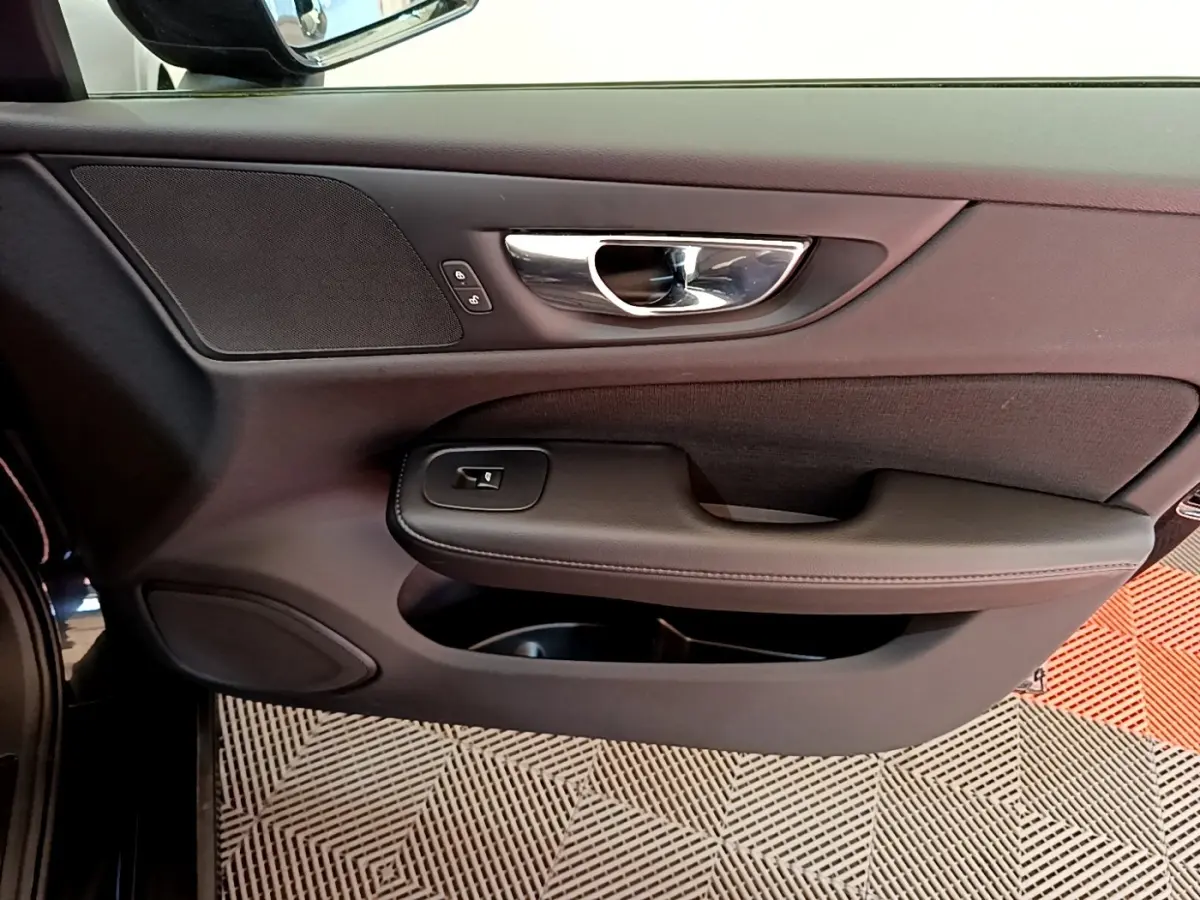 Vue rapprochée de la porte avant gauche noire du Volvo V60 2020, avec poignée chrome et commandes de verrouillage.