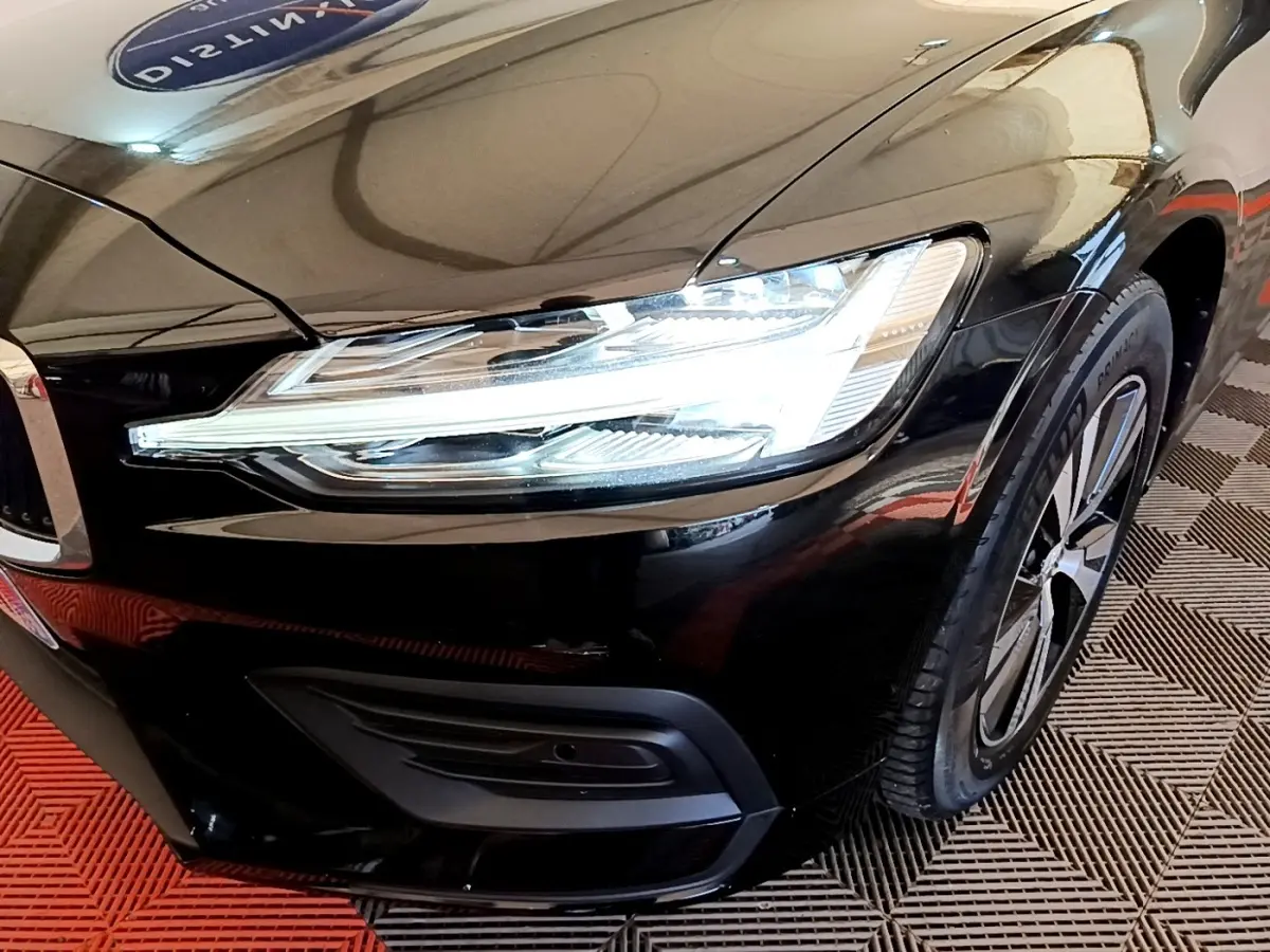 Gros plan sur l'avant droit noir d'une Volvo V60 2020, mettant en valeur le phare LED et la jante alliage.