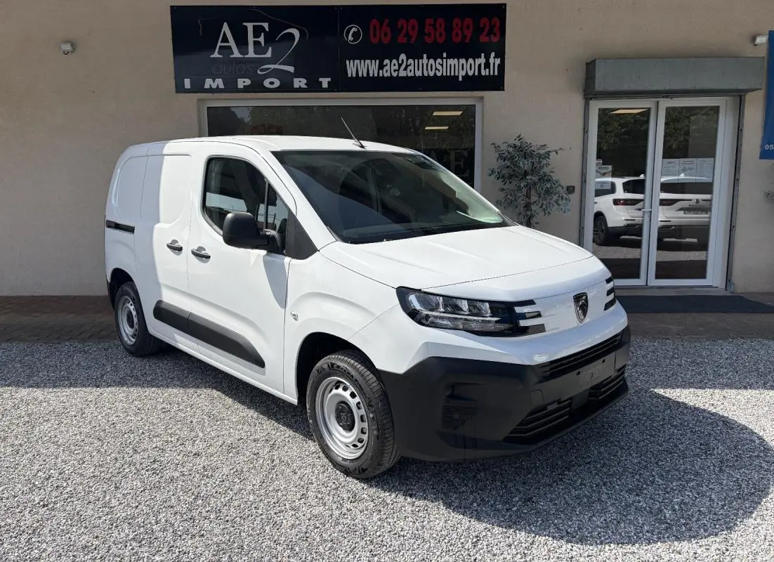 Peugeot Partner blanc en fourgon, vu en 3/4 avant droit, avec calandre noire et jantes acier simples.