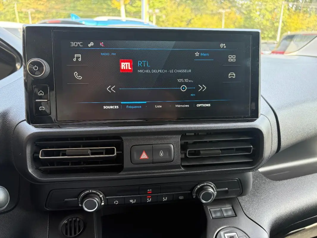 Vue rapprochée de l’écran tactile central du Peugeot Partner 2026 avec commandes de climatisation et ventilation.