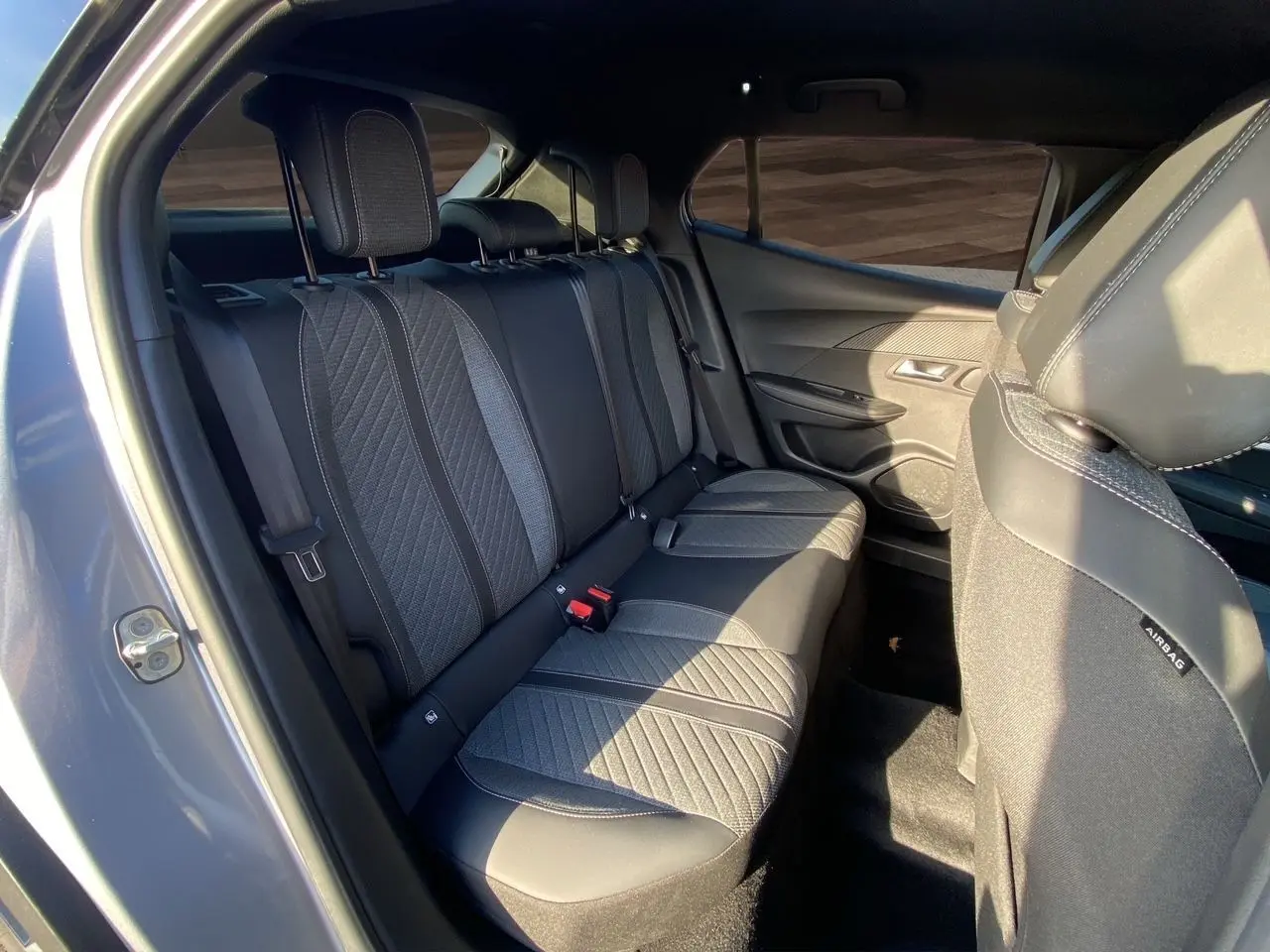 Vue intérieure côté gauche des sièges arrière en tissu noir et gris du Peugeot 2008 2024 gris Artense.