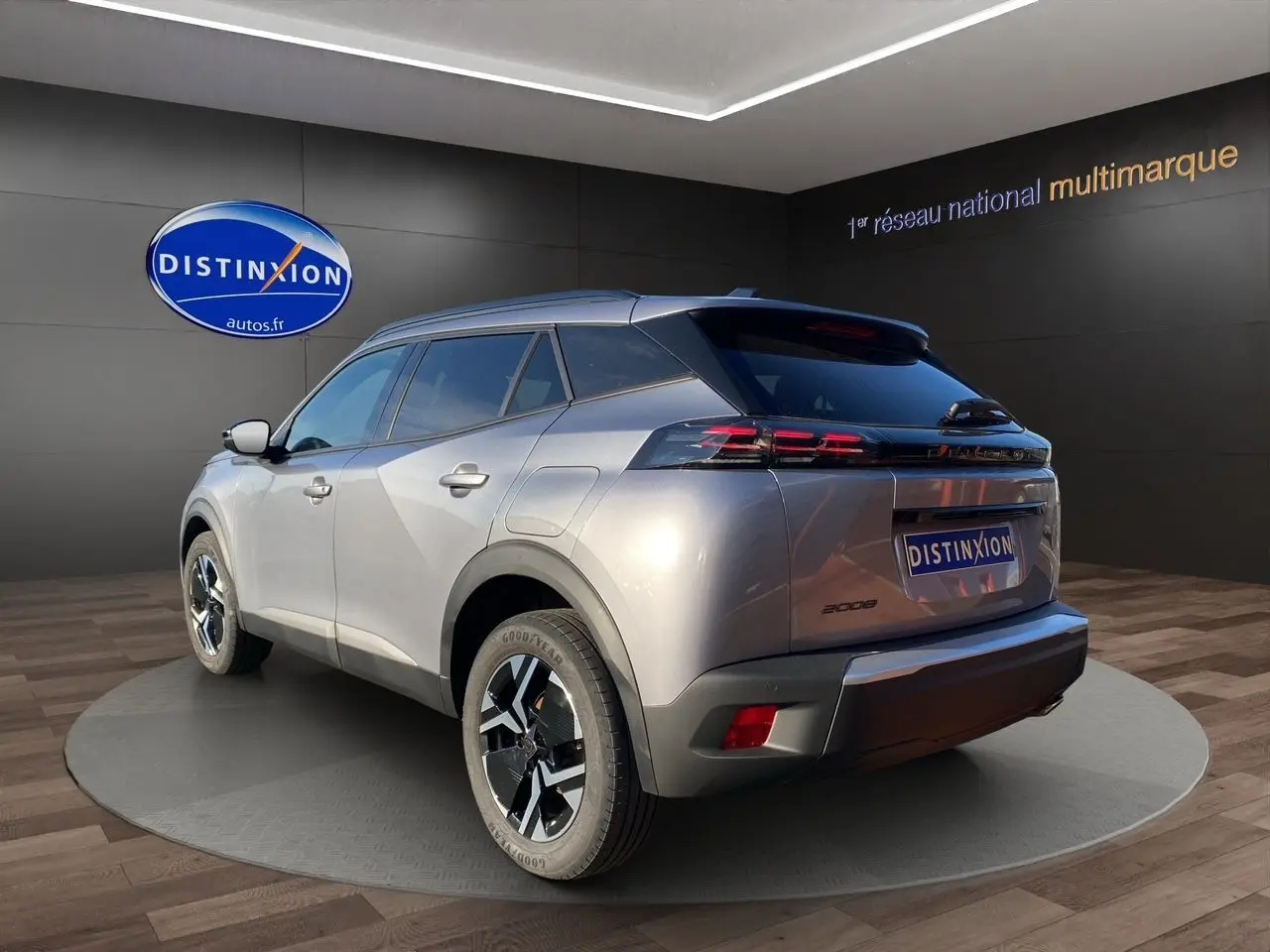 Vue 3/4 arrière droite d'un Peugeot 2008 gris Artense 2024 avec jantes noires et feux arrière LED distinctifs.