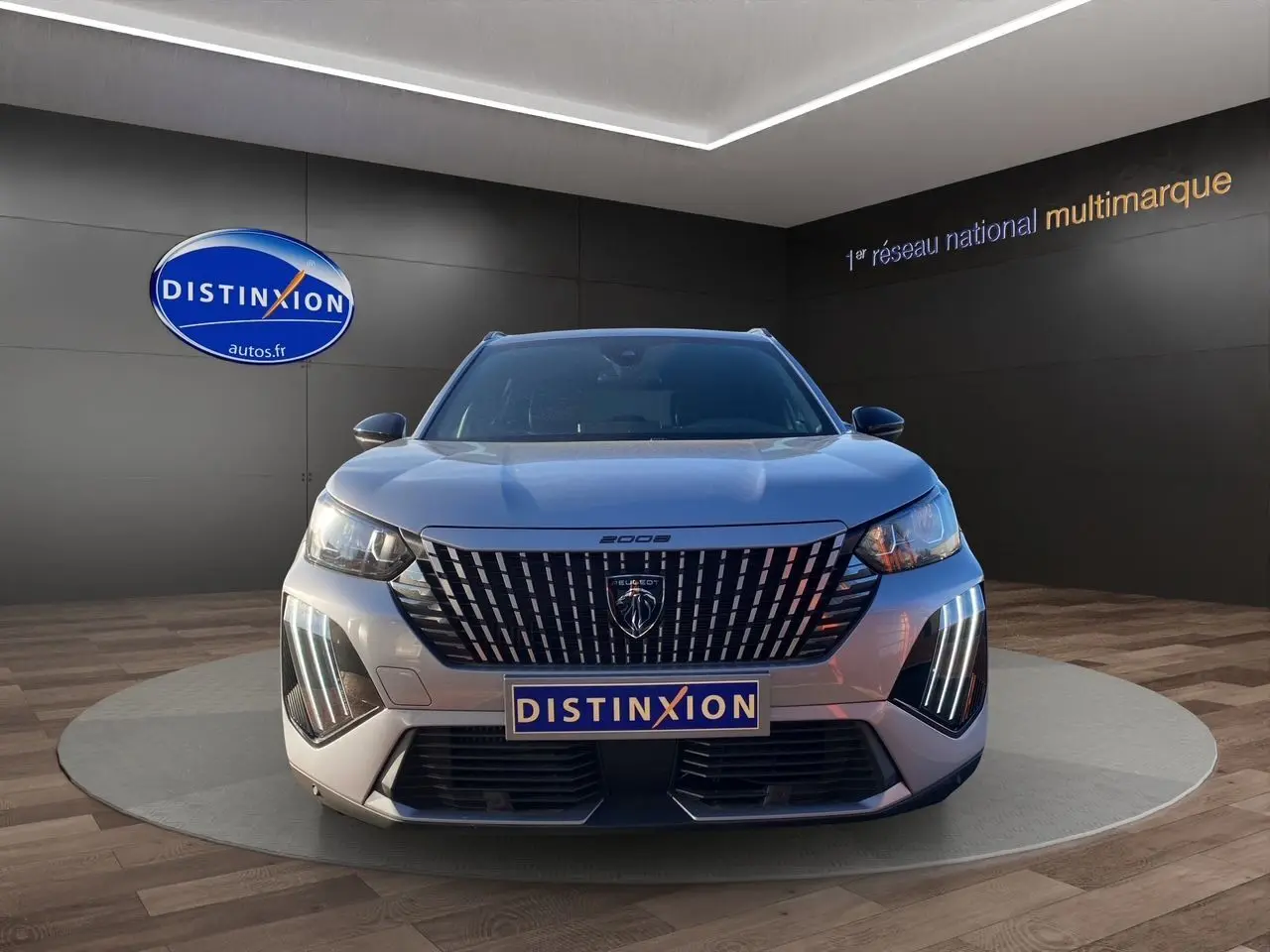 Vue frontale du Peugeot 2008 gris Artense avec sa calandre verticale distinctive et feux LED en éclairage diurne.