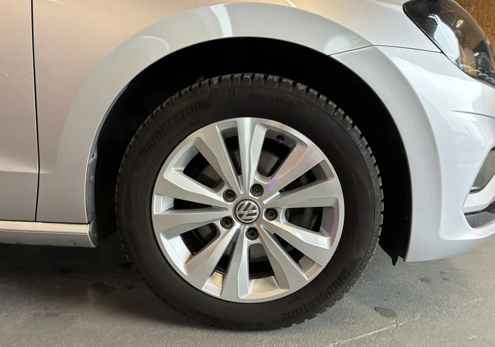 Gros plan sur la roue avant droite grise d'une Volkswagen Golf Sportsvan 2019 avec jante alliage et pneu Bridgestone.