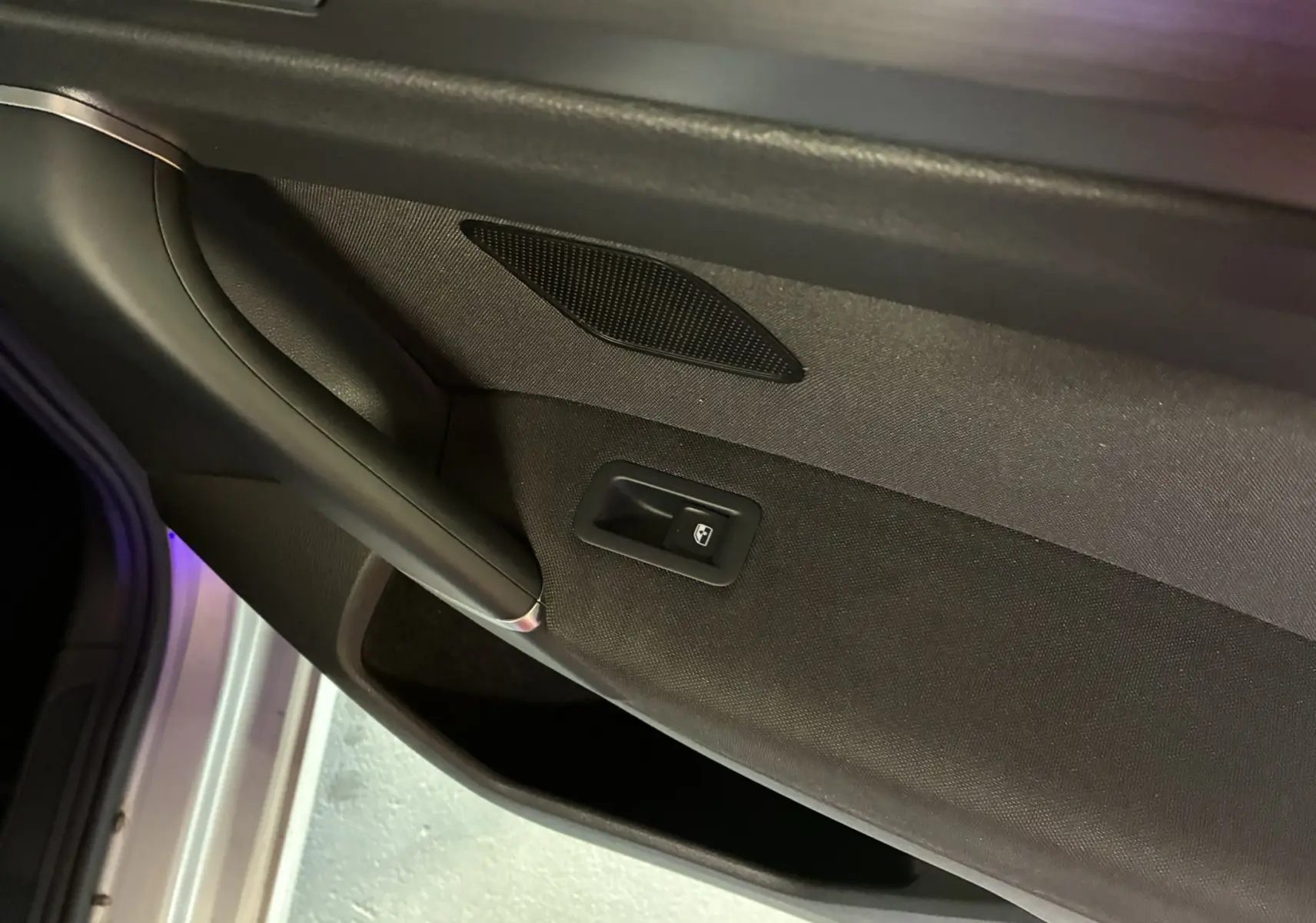 Détail de la porte intérieure côté gauche en tissu gris noir avec commande de vitre électrique sur Volkswagen Golf Sportsvan 2019.
