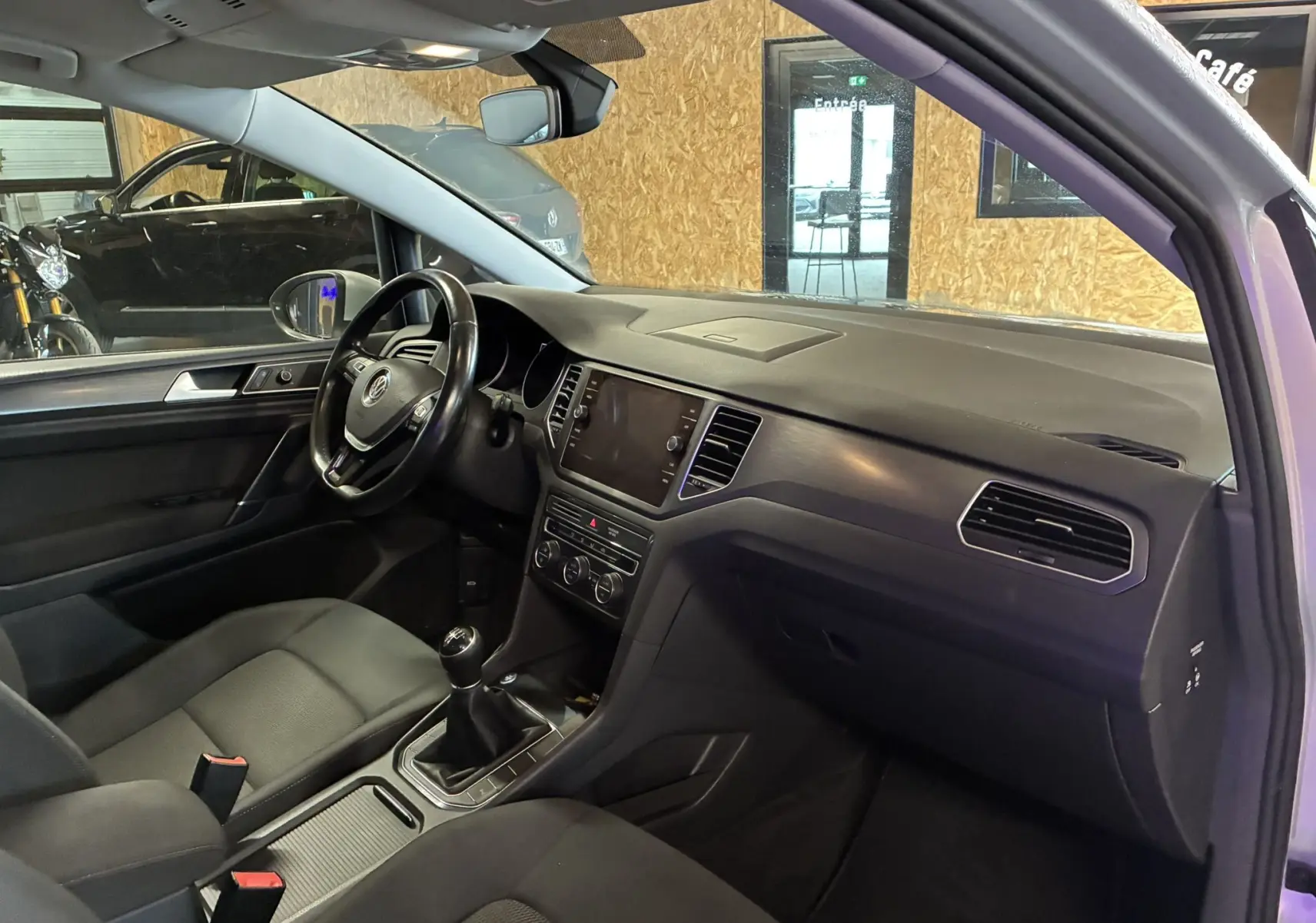 Intérieur gris noir de la Volkswagen Golf Sportsvan 2019, vue côté conducteur montrant tableau de bord et volant multifonction.