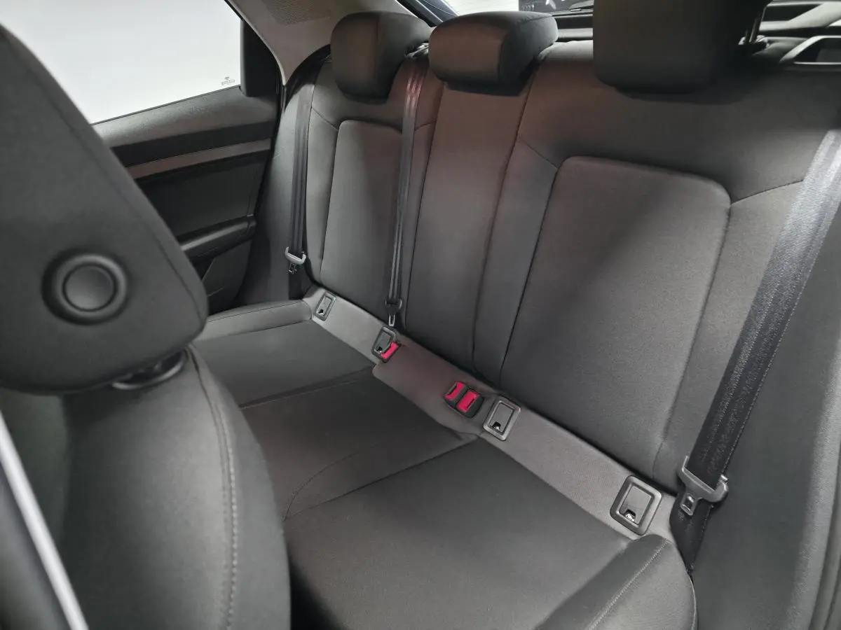 Vue arrière des sièges noirs en tissu Novum de l'Audi A1 Sportback 2024 avec ceintures de sécurité visibles.