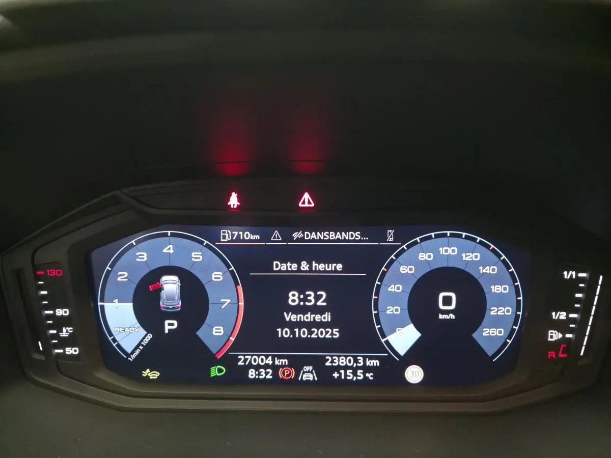 Affichage numérique du tableau de bord de l'Audi A1 Sportback gris, montrant vitesse, compte-tours et informations de conduite.