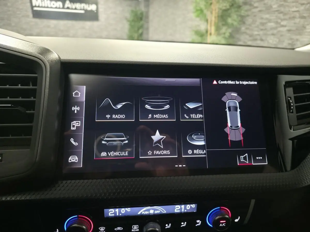Écran tactile central de l'Audi A1 Sportback 2024 montrant l'interface multimédia et l'aide au stationnement