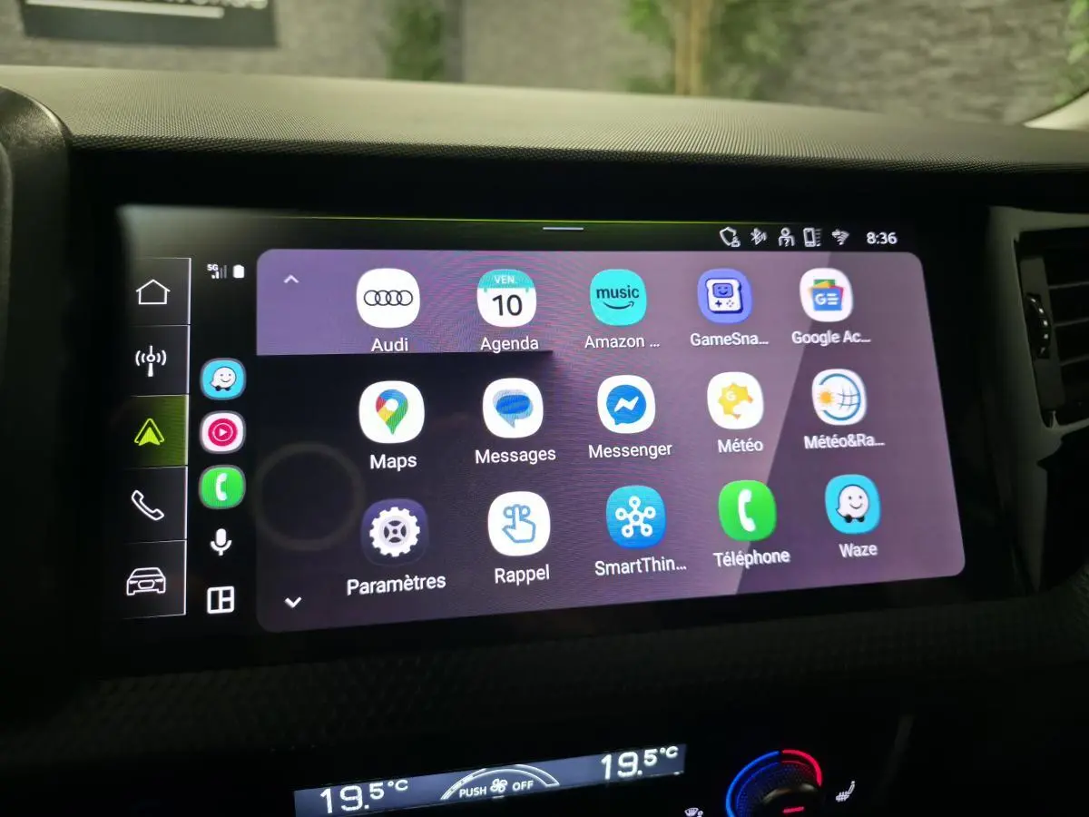 Écran tactile central de l'Audi A1 Sportback 2024 affichant les applications connectées, avec tableau de bord noir.
