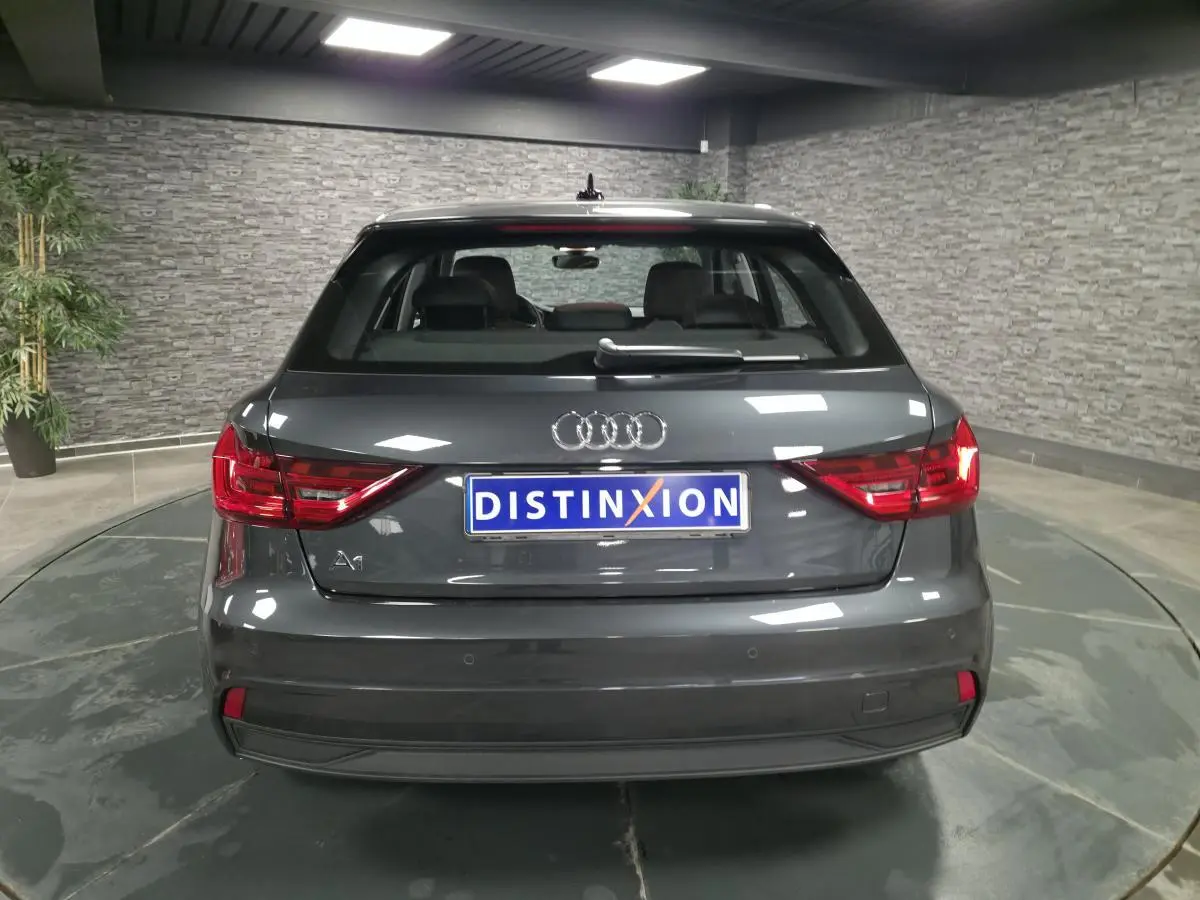 Vue arrière d'une Audi A1 Sportback gris Manhattan avec feux LED et logo distinctif au centre.