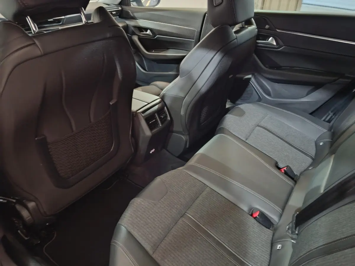 Vue intérieure arrière droit de la Peugeot 508 BlueHDi 130 Allure, sièges gris cuir et tissu avec console centrale et aérateurs.