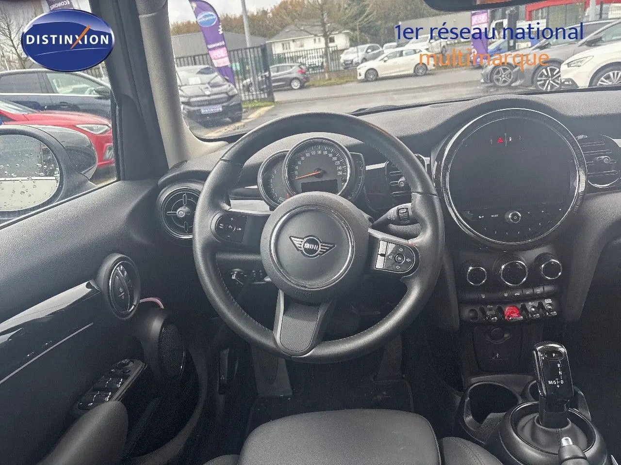 Vue intérieure centrée sur le volant et le tableau de bord d'une MINI 1.5 136CH gris rooftop avec boîte auto.