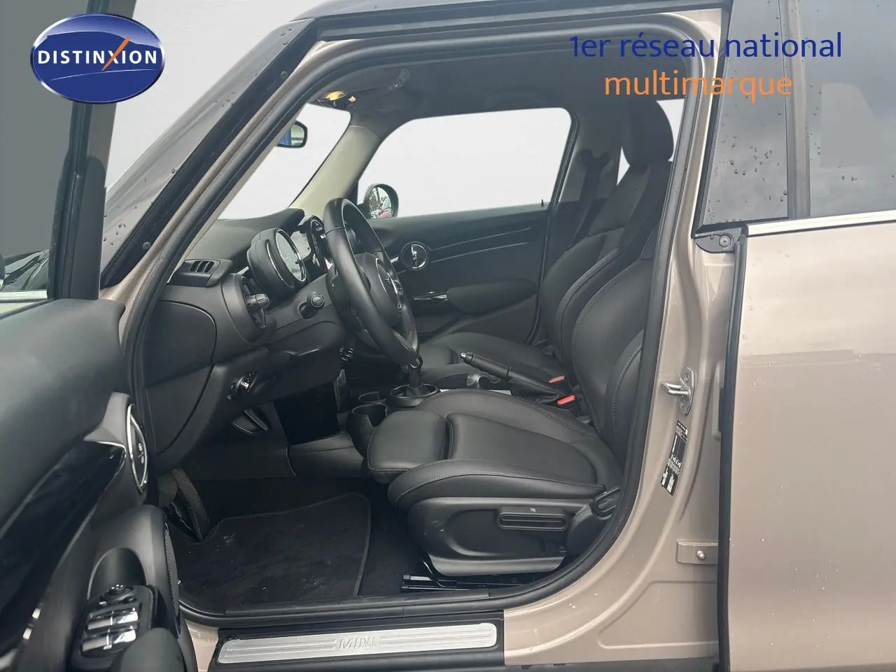 Intérieur noir vu côté conducteur d'une MINI 1.5 136CH Rooftop Grey Metal avec tableau de bord moderne.