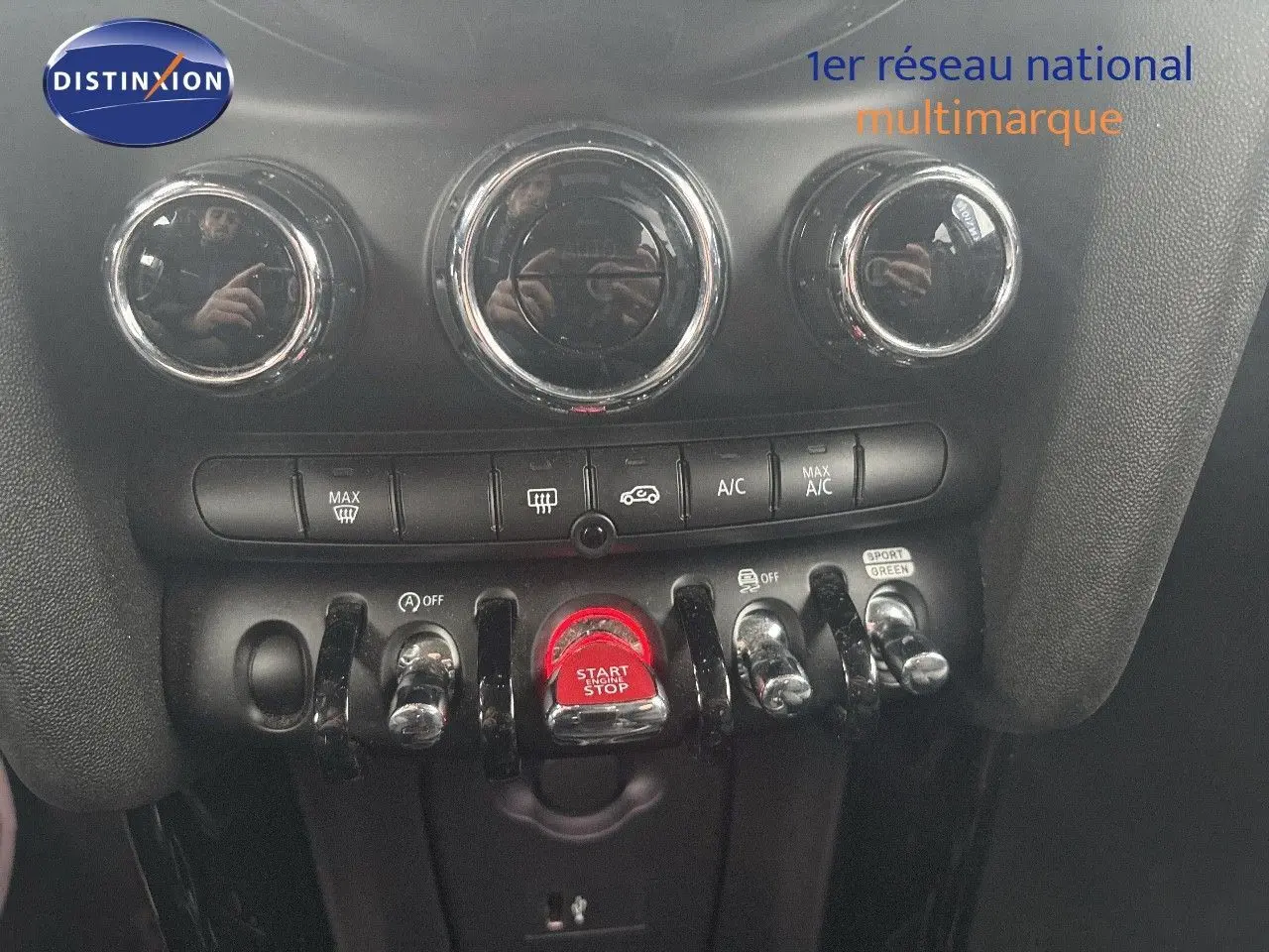 Vue rapprochée du tableau de bord de la MINI 2023 en rooftop grey, mettant en valeur les commandes de climatisation et le bouton start/stop rouge.